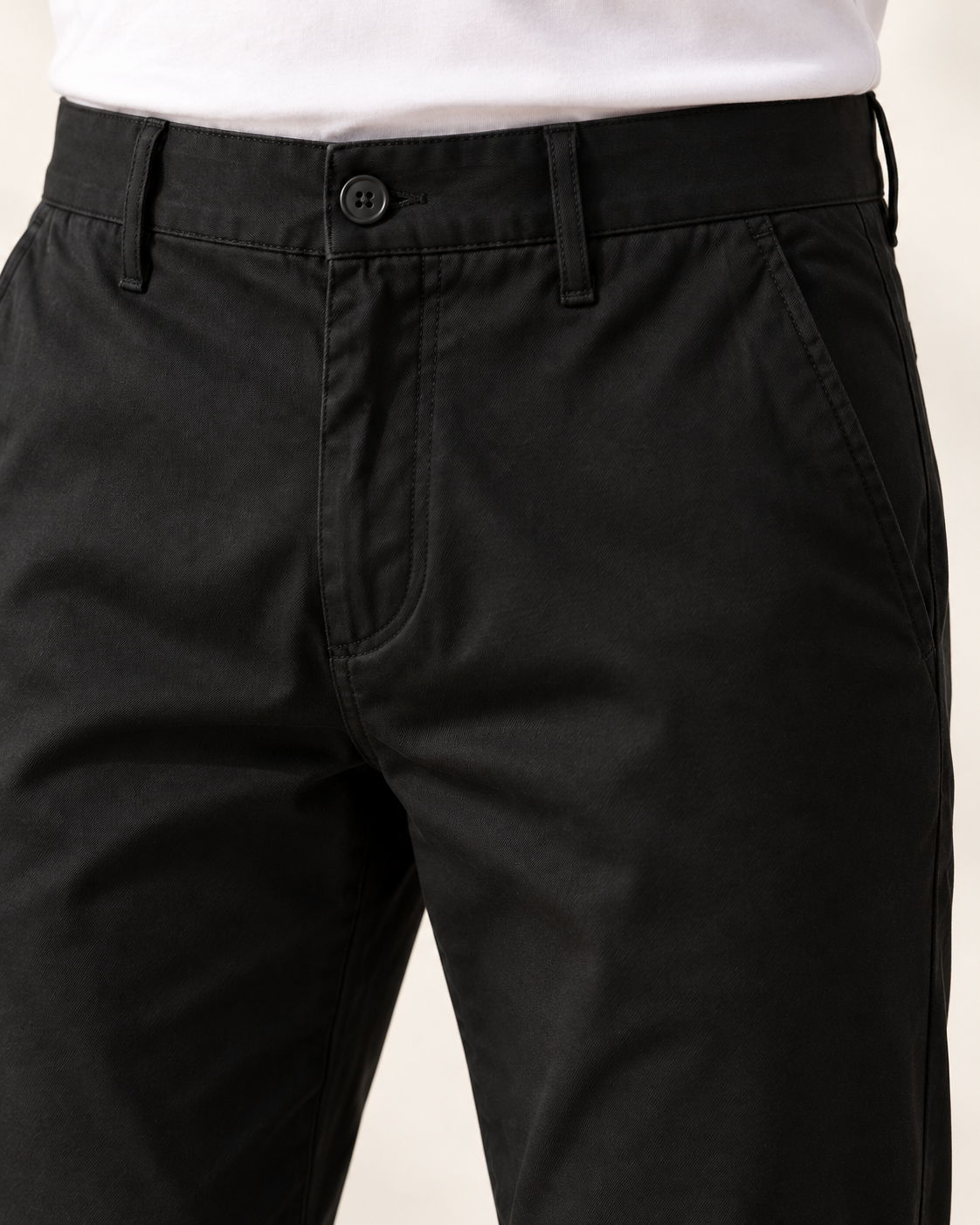 Dettaglio di bottone, cintura e tasca del pantalone nero