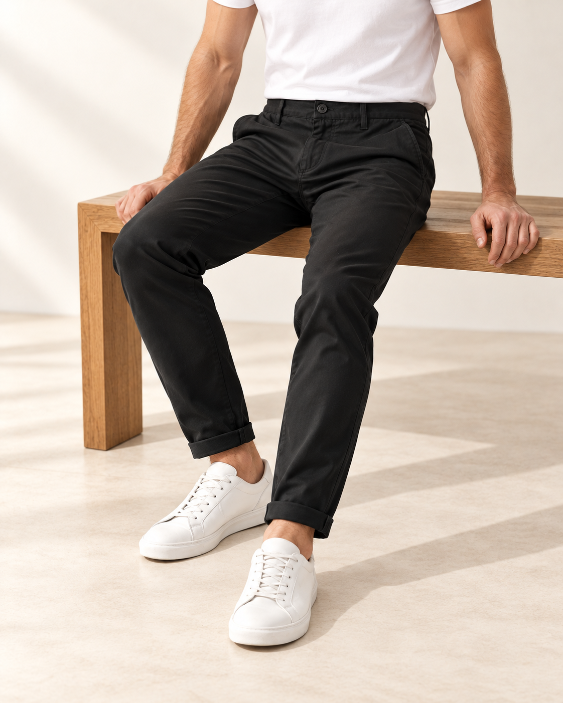 Uomo seduto su una panca con pantalone nero